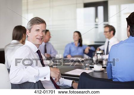 Businessman smiling in meeting View Large Photo Image Stock Image - Businessman smiling in meeting. Fotosearch