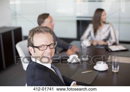 Businessman smiling in meeting View Large Photo Image Stock Image - Businessman smiling in meeting. Fotosearch