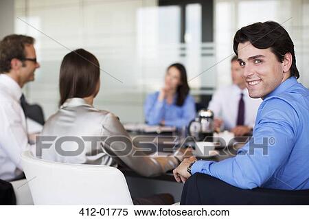 Stock Photography - Businessman smiling in meeting. Fotosearch