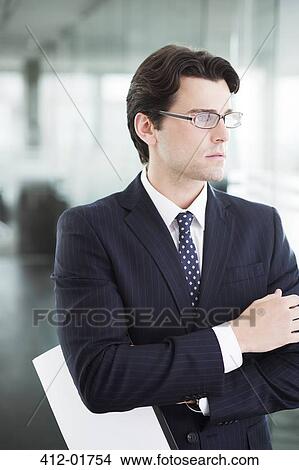 Businessman standing in office hallway View Large Photo Image Picture - Businessman standing in office hallway. Fotosearch