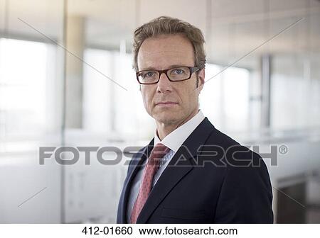 Businessman standing in office hallway View Large Photo Image Stock Image - Businessman standing in office hallway. Fotosearch