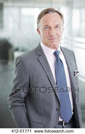 Businessman standing in office hallway View Large Photo Image Stock Image - Businessman standing in office hallway. Fotosearch