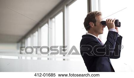 Businessman using binoculars at office window View Large Photo Image Stock Photography - Businessman using binoculars at office window. Fotosearch