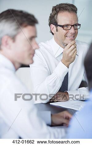 Businessmen sitting in meeting View Large Photo Image Stock Image - Businessmen sitting in meeting. Fotosearch