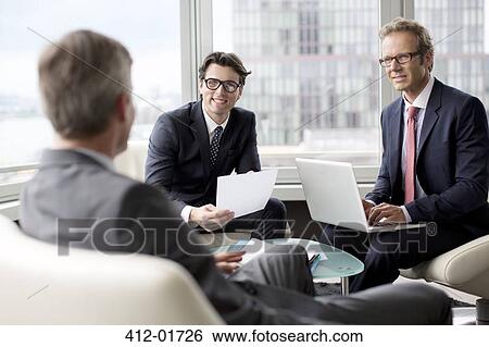 Businessmen talking in office area View Large Photo Image Stock Photograph - Businessmen talking in office area. Fotosearch