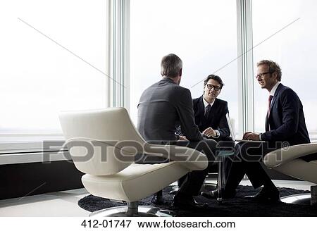 Businessmen talking in office lobby View Large Photo Image Stock Photo - Businessmen talking in office lobby. Fotosearch