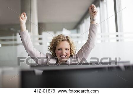 Stock Photo - Businesswoman cheering in office. Fotosearch