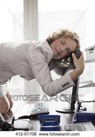 Stock Photo - Businesswoman hugging computer at desk. Fotosearch