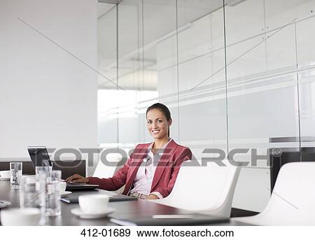 Stock Photo - Businesswoman smiling at meeting table. Fotosearch