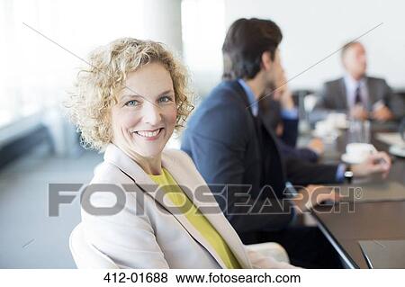 Businesswoman smiling in meeting View Large Photo Image Stock Photo - Businesswoman smiling in meeting. Fotosearch
