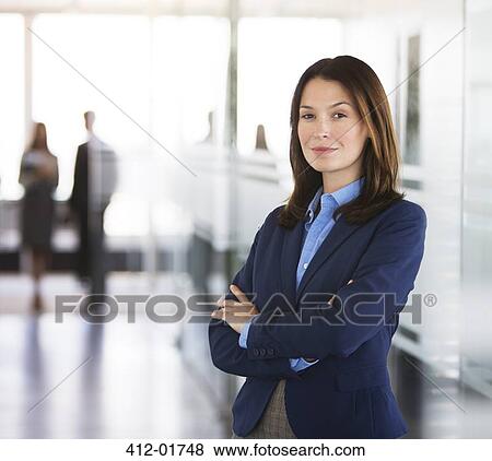 Businesswoman standing in office hallway View Large Photo Image Stock Photo - Businesswoman standing in office hallway. Fotosearch