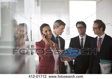 Businesswoman talking on cell phone in office hallway View Large Photo Image Stock Image - Businesswoman talking on cell phone in office hallway. Fotosearch
