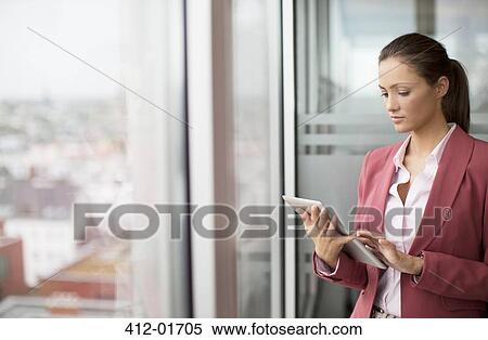 Businesswoman using digital tablet in office View Large Photo Image Stock Photography - Businesswoman using digital tablet in office. Fotosearch