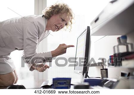 Businesswoman yelling at computer in office View Large Photo Image Stock Photo - Businesswoman yelling at computer in office. Fotosearch