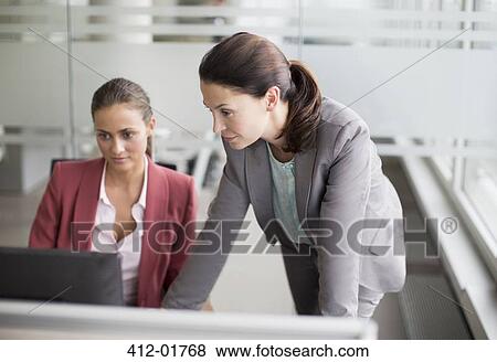 Businesswomen working together at desk View Large Photo Image Stock Photo - Businesswomen working together at desk. Fotosearch