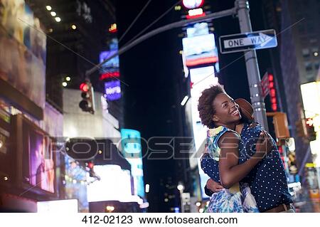 Couple hugging on city street at night View Large Photo Image Stock Image - Couple hugging on city street at night. Fotosearch