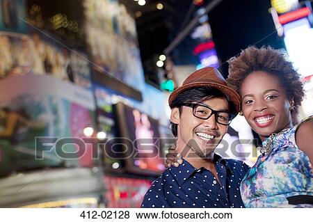 Couple smiling together on city street View Large Photo Image Stock Photo - Couple smiling together on city street. Fotosearch