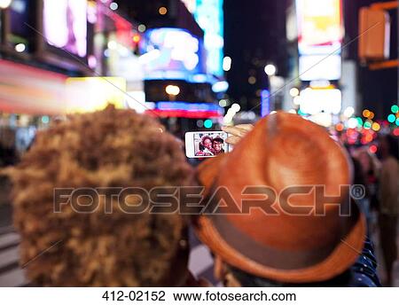 Couple taking picture together on city street View Large Photo Image Stock Image - Couple taking picture together on city street. Fotosearch