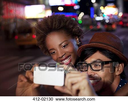 Couple taking pictures on city street View Large Photo Image Stock Image - Couple taking pictures on city street. Fotosearch