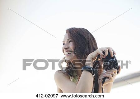 Smiling woman taking pictures outdoors View Large Photo Image Stock Photo - Smiling woman taking pictures outdoors. Fotosearch