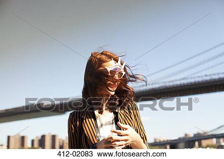 Stock Image - Woman in novelty sunglasses by city cityscape. Fotosearch