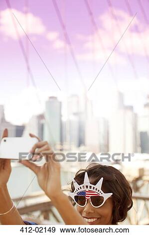 Woman in novelty sunglasses taking picture by city cityscape View Large Photo Image Stock Photo - Woman in novelty sunglasses taking picture by city cityscape. Fotosearch