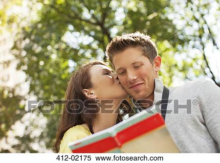 Woman kissing boyfriend in park View Large Photo Image Stock Photography - Woman kissing boyfriend in park. Fotosearch