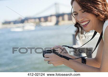 Woman taking picture by urban bridge View Large Photo Image Picture - Woman taking picture by urban bridge. Fotosearch