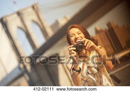 Woman taking picture by urban bridge View Large Photo Image Stock Image - Woman taking picture by urban bridge. Fotosearch