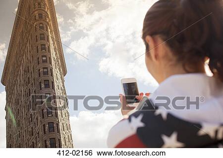 Stock Photograph - Woman taking picture of highrise. Fotosearch