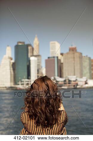 Stock Image - Woman taking picture of urban cityscape. Fotosearch