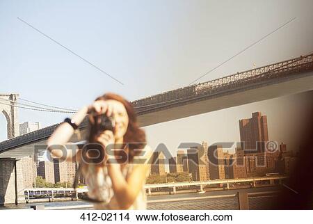 Woman taking pictures by urban bridge View Large Photo Image Picture - Woman taking pictures by urban bridge. Fotosearch