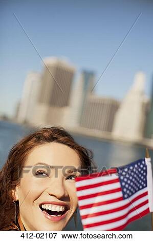 Woman waving American flag by city cityscape View Large Photo Image Stock Photo - Woman waving American flag by city cityscape. Fotosearch