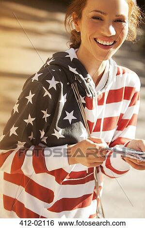 Stock Photograph - Woman wearing American flag sweatshirt. Fotosearch