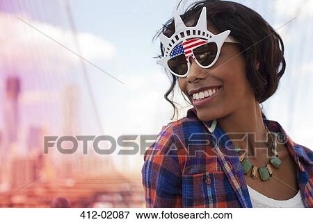 Woman wearing novelty sunglasses on city street View Large Photo Image Stock Photo - Woman wearing novelty sunglasses on city street. Fotosearch