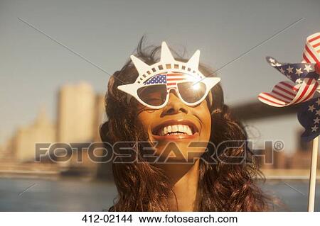 Woman with novelty sunglasses and pinwheel by urban bridge View Large Photo Image Picture - Woman with novelty sunglasses and pinwheel by urban bridge. Fotosearch