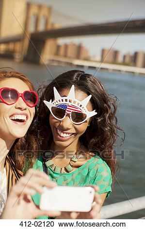 Women in novelty sunglasses taking picture by city cityscape View Large Photo Image Stock Image - Women in novelty sunglasses taking picture by city cityscape. Fotosearch