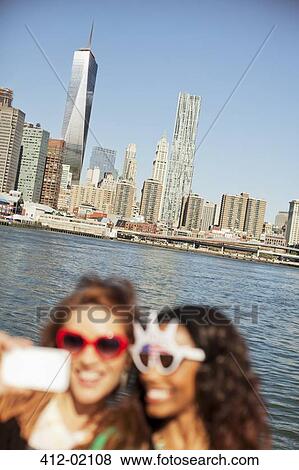 Women in novelty sunglasses taking picture by city cityscape View Large Photo Image Stock Photo - Women in novelty sunglasses taking picture by city cityscape. Fotosearch