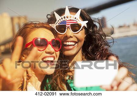 Women taking picture of themselves in novelty sunglasses View Large Photo Image Stock Image - Women taking picture of themselves in novelty sunglasses. Fotosearch