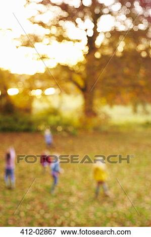 Stock Photo - Blurred view of children in field. Fotosearch