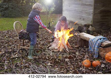 Picture - Children building bonfire outdoors. Fotosearch