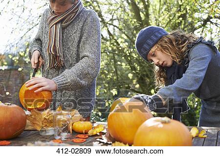 Children carving pumpkins together outdoors View Large Photo Image Stock Photo - Children carving pumpkins together outdoors. Fotosearch