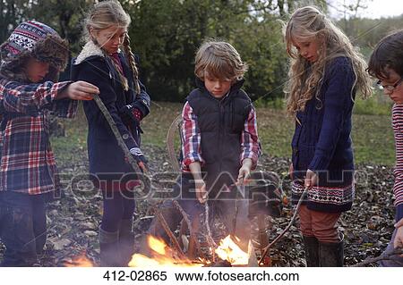 Children poking bonfire outdoors View Large Photo Image Stock Photography - Children poking bonfire outdoors. Fotosearch