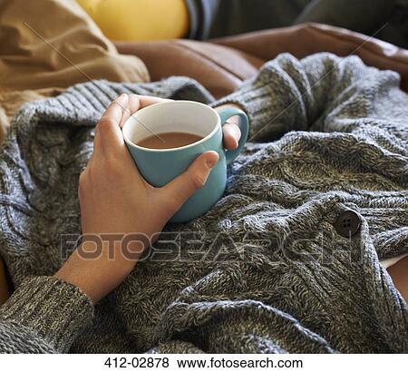 Stock Photo - Close up of boy holding cup of tea. Fotosearch