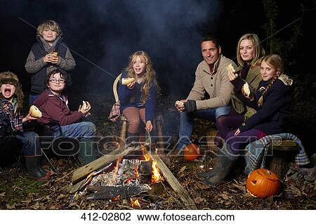Family eating around campfire at night View Large Photo Image Stock Image - Family eating around campfire at night. Fotosearch