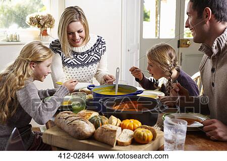 Family eating together at table View Large Photo Image Picture - Family eating together at table. Fotosearch