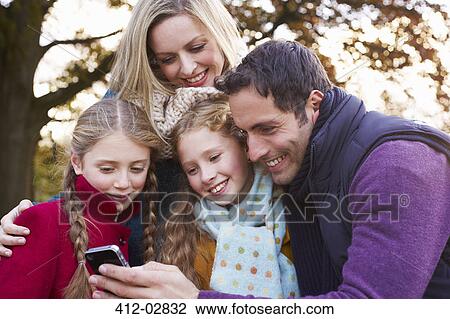 Family using cell phone outdoors View Large Photo Image Stock Image - Family using cell phone outdoors. Fotosearch