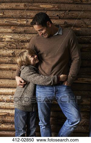 Stock Image - Father and son hugging outdoors. Fotosearch
