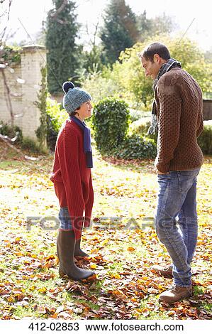 Stock Image - Father and son walking in autumn leaves. Fotosearch