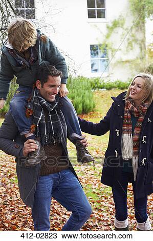 Stock Image - Father carrying son on shoulders. Fotosearch